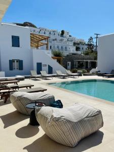 a swimming pool with chaise lounge chairs next to a swimming pool at Esperides in Platis Gialos