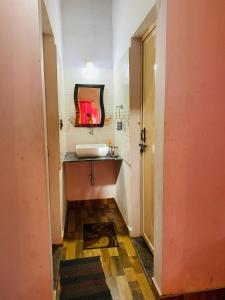 a bathroom with a sink and a mirror at Timber leaf stay in Avathi