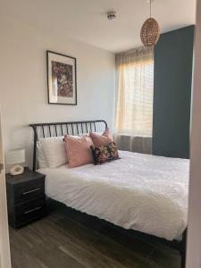 ein Schlafzimmer mit einem Bett mit Kissen und einem Fenster in der Unterkunft Central Flat in Brighton's Lanes - 5 Min walk from beach and Pier - 10 mins by car from station - up to 6 guests! in Brighton & Hove