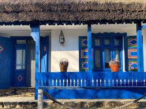 a building with blue doors and baskets on it at Casa Soarelui in Murighiol