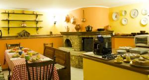 a kitchen with a table and a stove and a fireplace at La Bertina in Montefiascone