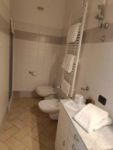 Baño blanco con aseo y lavamanos en Residence Borromeo en Cesano Maderno