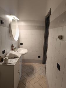 Baño blanco con lavabo y espejo en Residence Borromeo en Cesano Maderno