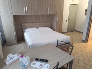Habitación de hotel con 1 cama y 2 mesas en Residence Borromeo en Cesano Maderno