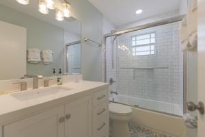 Un baño blanco con lavabo e inodoro. en Down Time, en Sanibel 25 fotos más