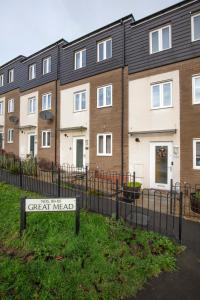 a sign in front of a row of houses at Spacious Modern House with Free Parking 