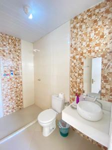 La salle de bains est pourvue de toilettes, d'un lavabo et d'une baignoire. dans l'établissement ilha de Itaparica casa ilhamar, 
