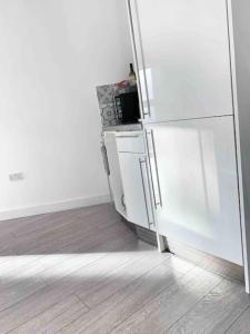frigorifero bianco in camera con pavimento in legno di New City Centre Apartment in Nottingham a Nottingham