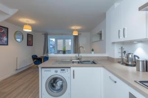 a kitchen with a washing machine and a sink at Spacious Modern House with Free Parking 