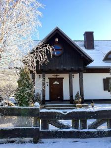 a house with a snow covered porch and a door at Siedlisko pod Aniołem in Grabówko