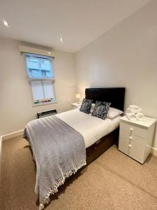 um quarto com uma cama grande e uma janela em Superb 2Bed/2Bath Flat Waterloo London em Londres