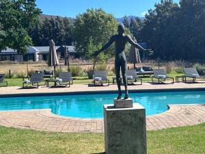 a statue of a woman standing next to a pool at Lynx Wine Estate in Franschhoek