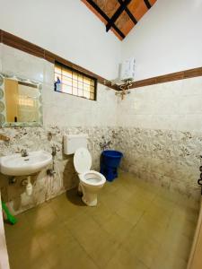 a bathroom with a toilet and a sink at Timber leaf stay in Avathi