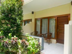 a house with a porch with a table and chairs at Marine Bay Sanur in Sanur