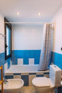 a bathroom with a tub and a toilet and a sink at Paradise Beach House: piscina privada, playa 100m in Corralejo
