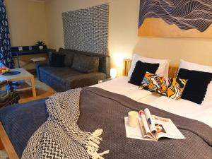 a bedroom with a bed with a book and a couch at Elegant Old Town Toffee Bliss Apartment, SELF Check-In, Steps from Bus Station in Riga +27 photos