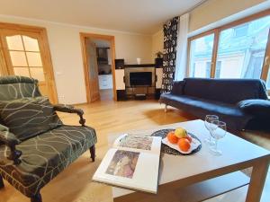 a living room with a couch and a coffee table at Elegant Old Town Toffee Bliss Apartment, SELF Check-In, Steps from Bus Station in Riga