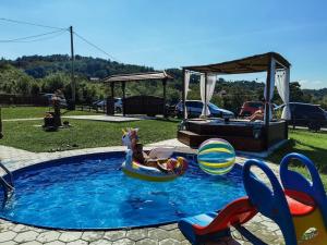 Uma mulher está a montar um unicórnio numa jangada numa piscina. em Family House Maksimović em Valjevo