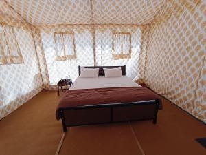 een slaapkamer met een bed in een kamer met behang bij Rann Heritage Resort in Dhordo