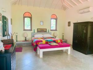 1 dormitorio con 1 cama con una manta colorida en Shangri-lanka Villa, en Bentota