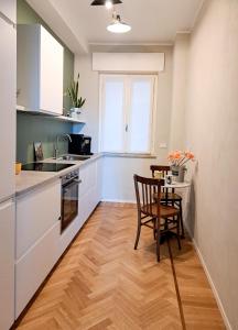 a kitchen with a table and a chair in it at ALBORGOCOLLEGIOMARIALUIGIA in Parma