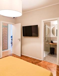 a bedroom with a flat screen tv on the wall at ALBORGOCOLLEGIOMARIALUIGIA in Parma