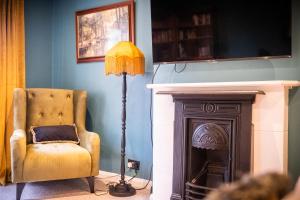 una lámpara de pie y una silla en una habitación con chimenea en Reigate Gem en Redhill