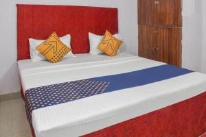 a bed with orange and blue pillows in a room at SPOT ON Hotel Krrish in Durg