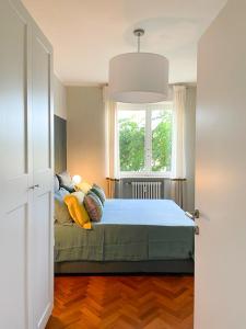 a bedroom with a bed with pillows and a window at ALBORGOCOLLEGIOMARIALUIGIA in Parma
