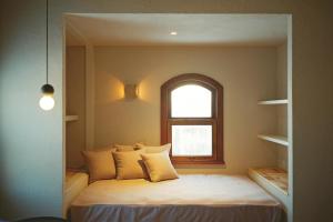 a small bedroom with a bed with a window at Portside Inn Hakodate in Hakodate