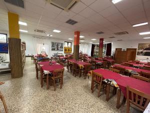 a dining room with red tables and wooden chairs at Beteyà Hostel Don Bosco in Catania