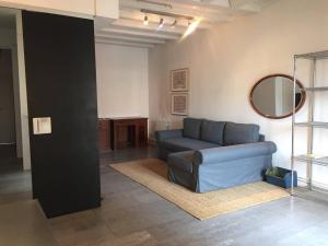 - un salon avec un canapé bleu et un miroir dans l'établissement Beautiful & Bright Apartment Near Ramblas, à Barcelone