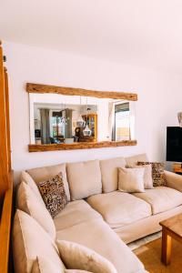 a living room with a couch and a mirror at Paradise Beach House: piscina privada, playa 100m in Corralejo