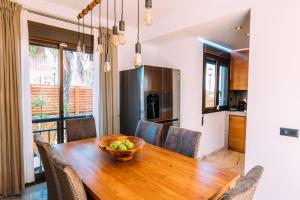 a dining room with a wooden table with a bowl of fruit at Paradise Beach House: piscina privada, playa 100m in Corralejo