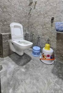 a bathroom with a toilet and a sink in it at Hotel Rudrax - Anand in Anand
