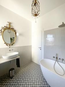 a bathroom with a tub and a sink and a mirror at ALBORGOCOLLEGIOMARIALUIGIA in Parma +11 photos