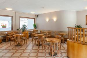 a restaurant with wooden tables and stools at Residence Stofol in Aprica