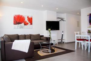 un salon avec un canapé et une table dans l'établissement Ferienwohnungen Moselterrasse, à Detzem