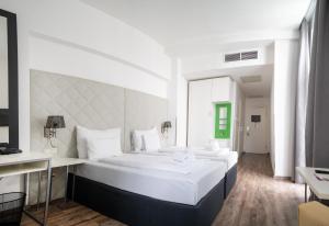 um amplo quarto branco com 2 camas grandes em Safestay Vienna Margaretenviertel em Viena