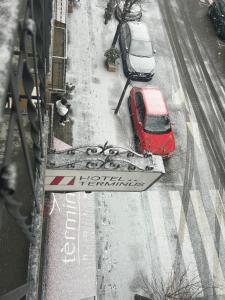 two cars parked on a street in the snow at Hotel Terminus in Puigcerdà