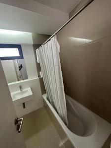 a bathroom with a shower curtain and a sink at MADEIRA SHOPPING- 10min to Funchal in Funchal