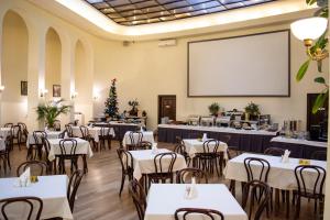 una sala da pranzo con tavoli e schermo di proiezione di George Hotel a Lviv