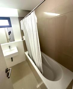 a bathroom with a shower curtain and a sink at MADEIRA SHOPPING- 10min to Funchal in Funchal