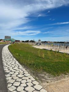 una carretera de adoquines junto a una playa y el océano en 99 Lifestyle Suite, en Zwaag