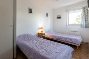 two beds in a room with a window at Cap-ferret Phare Réf 130 in Lège-Cap-Ferret