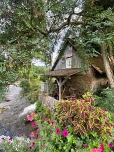 a small house sitting next to a river with flowers at KELLER APARTMENT I 106 Kniebis in Freudenstadt