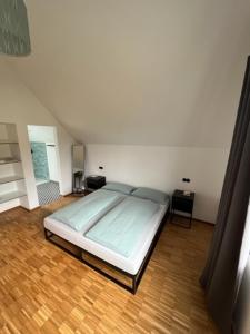 a bedroom with a bed and a wooden floor at Eifel-Bau-Traum Schlich in Wershofen