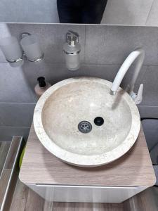 lavabo blanco en el baño con encimera en Apartmani M.&.B Luks en Mataruška Banja