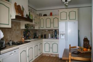 een keuken met witte kasten en een witte koelkast bij villa la Prairie in Boulbon