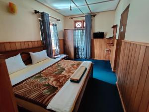 a bedroom with a large bed with a wooden headboard at Carnation Rest in Nuwara Eliya